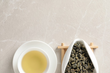 Cup of Tie Guan Yin oolong and chahe with tea leaves on table, top view. Space for text