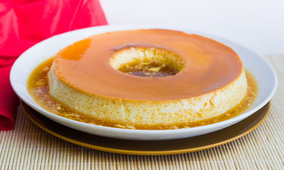 Milk Pudding or Pudim de leite. Brazilian dessert homemade caramel custard pudding and condensed milk. Traditional brazilian flan. Blurred background.