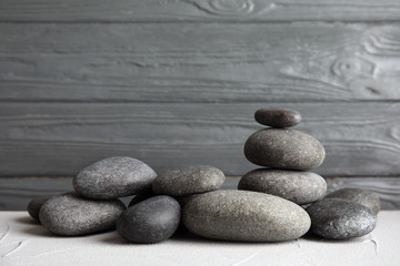 Zen stones on table against wooden background. Space for text