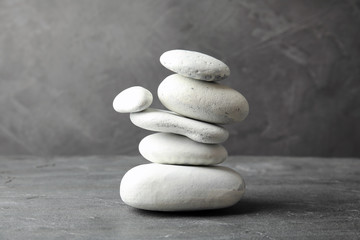 Fototapeta na wymiar Stack of zen stones on table against grey background