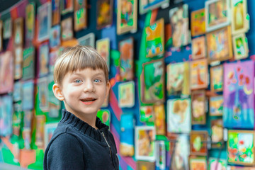 Surprised and joyful boy at an exhibition of paintings in the art gallery.