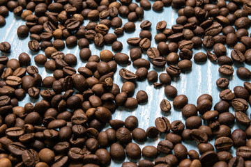 Roasted coffee beans in bulk on a blue wooden background