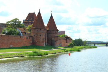 Fototapeta na wymiar Malbork Castle across the river Nogat
