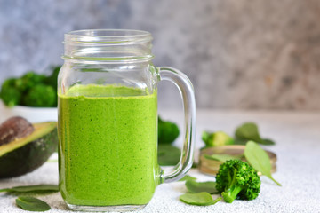 Green vegetable smoothie on a concrete background. Detox menu.
