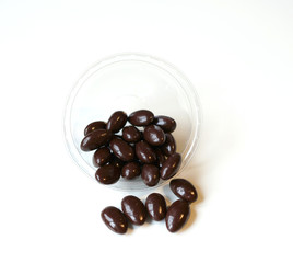 Food image close up candy, chocolate milk, extra dark almond nuts. Texture on top view background on the cup plate