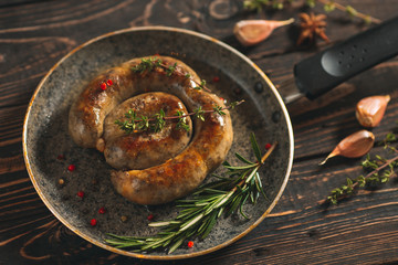 Fried sausages with garlic n the pan. On the dark Board.