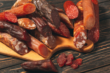 Different types of sausages and meat products on a wooden Board