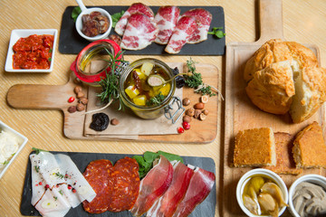 Cutting board with prosciutto, salami,bread on dark stone background.
