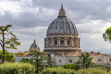 Obraz premium St. Peter's Basilica - A closeup view of the dome of St. Peter's Basilica, as seen from a hilltop in Vatican Gardens, on a cloudy October morning. Vatican City, Rome, Italy. 