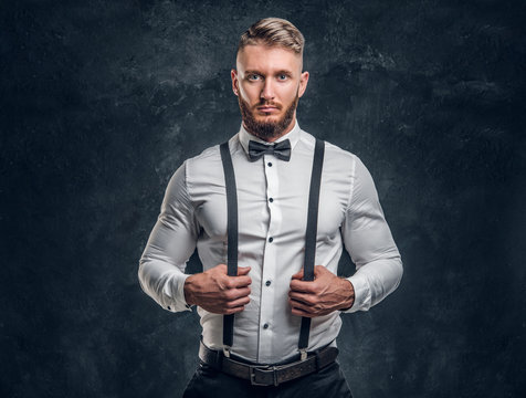 Stylishly dressed young man in shirt with bow tie and suspenders. Studio  photo against a dark wall background foto de Stock | Adobe Stock