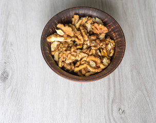 Obraz na płótnie Canvas Healthy food for background image close up walnuts. Nuts texture on white grey table top view on the cup plate