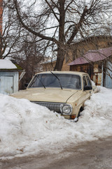 old car littered with snow