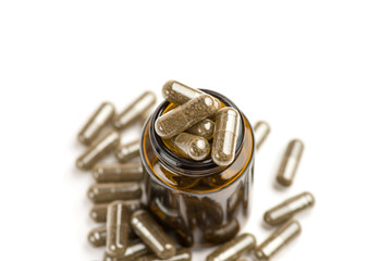 Medicine brown pills in the brown glass bottle on white background.