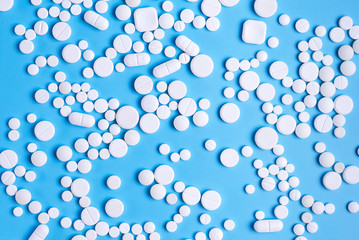 White pills or capsules on a blue background