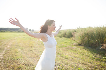 Beautiful caucasian girl walking on the field. Summer time day