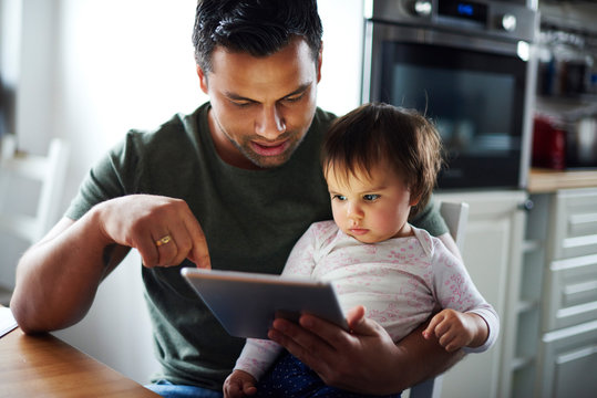 Father and baby girl using tablet at home