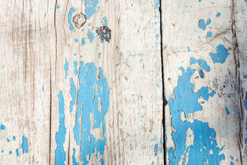 Fototapeta na wymiar cracked horizontal wooden panel with peeling blue paint