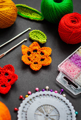 flat lay of knitting crochet elements, crochet hooks, skeins of thread, beads and needles