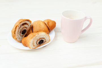 Fresh Croissant with chocolate on the white wooden background