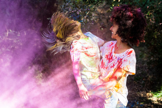 Mother and son full of colorful powder paint, celebrating Holi, Festival of Colors