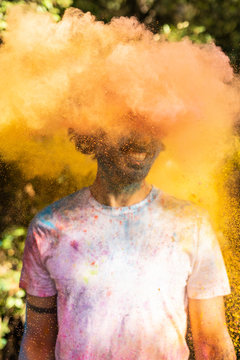 Man shaking his head, full of colorful powder paint, celebrating Holi, Festival of Colors