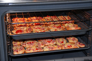 Hot sandwiches with sausage and melted cheese cooking in name-plate. Cooking tasty dish