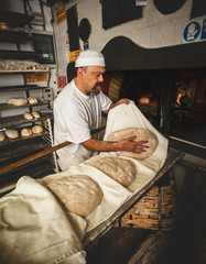 Production of baked bread with a wood oven in a bakery.