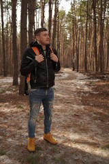 Fototapeta premium Traveler Man with backpack hiking Travel Lifestyle concept. The traveler goes through the forest