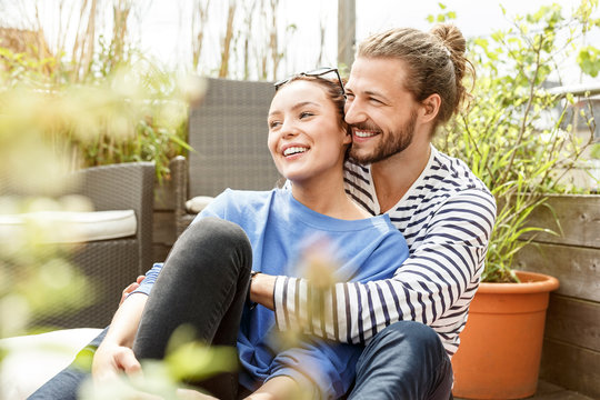 Young couple relaxing on their balcony, embracing