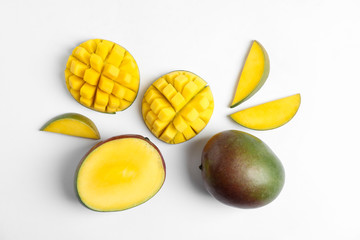 Flat lay composition with ripe mangoes on white background