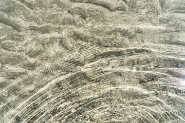 Transparent water surface and sand on the lake bottom