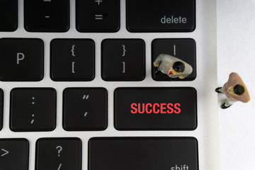 SUCCESS inscription written words, laptop and businessman miniature. Business and technology concept