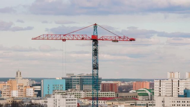 Tower crane working on construction site elevate weight, urban development residential building sunny evening, cityscape