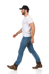 Happy Walking Man In White T-shirt, Jeans, Boots And Black Cap