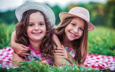 Two little girls enjoying in picnic. Childhood, nature, lifestyle