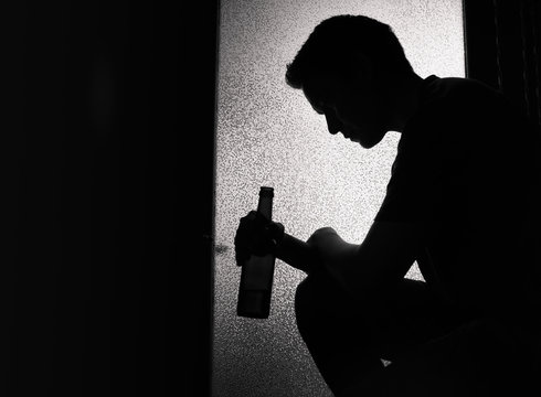 Silhouette Of A Young Sad Man Drinking Alcohol Alone