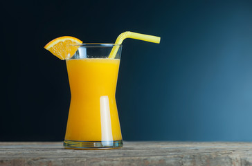 freshly squeezed orange juice in glass with orange fruits on wooden background, bitter seville fresh oranges citrus fruit concept