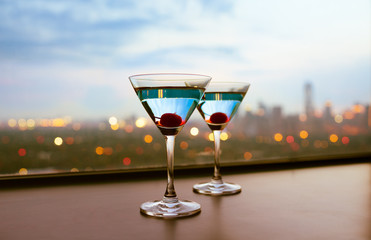 glass of cocktails on city sunset background 