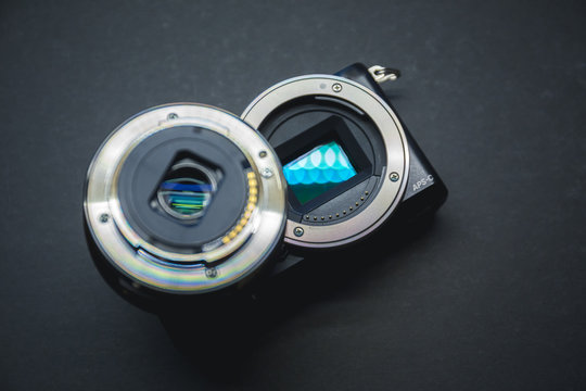Close-up of mirrorless digital APS-C camera with deattached lens.