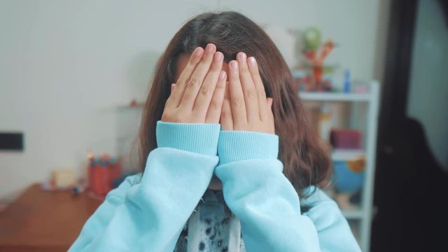 peek a boo. little girl covered her eyes face with her hands hide-and-seek waiting for lifestyle a surprise. slow motion video. teen girl playing bo-peep. childhood concept game hy - spy