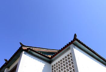 The corner of the ancient building against the blue sky