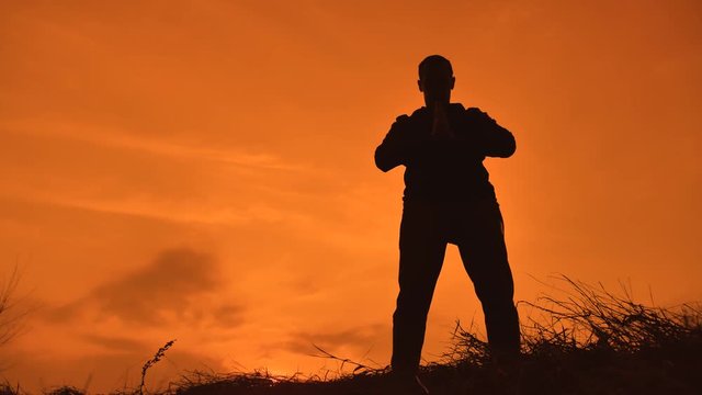 man martial arts concept. male warrior monk practicing kung fu. silhouette of a man at sunset engaged in martial arts karate lifestyle