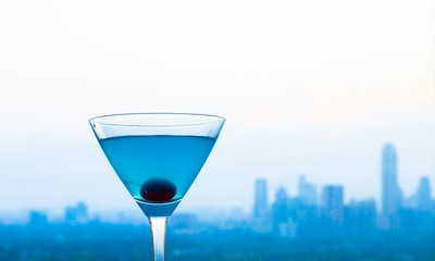 Cocktail glass against city background 