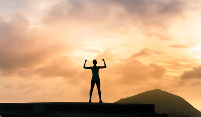 success and achievement, Strong young woman flexing on a mountain