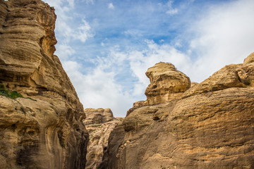 Fototapeta premium canyon rocks highland natural scenic landscape object from below on contrast blue sky with white clouds wilderness and dangerous outdoor environment