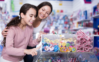 Woman with girl buying candies in the candy shop