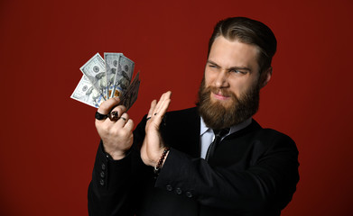 Modern business man hand holding American dollars hundreds banknotes butreat it with suspuicion and...