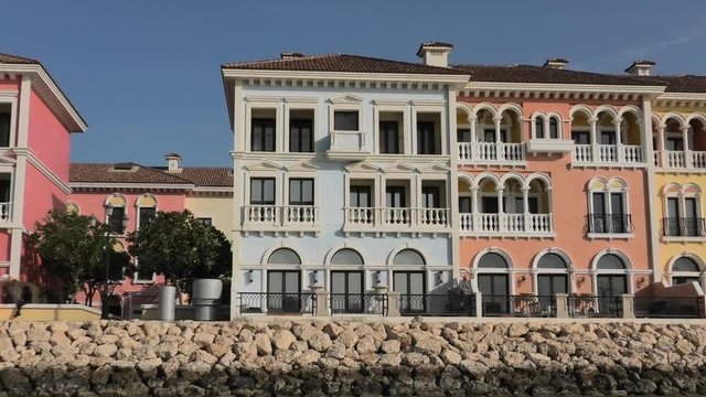 Scenic landscape of Venice at Qanat Quartier in the Pearl-Qatar, Persian Gulf, Middle East. Panoramic view of Venetian houses reflecting on canals of picturesque and luxurious district of Doha, Qatar.