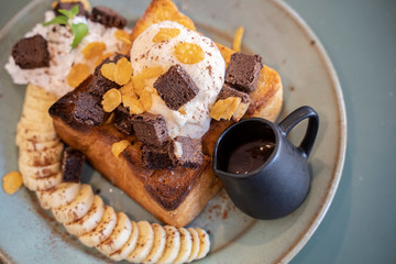 Ice cream, honey bread with bananas and brownies served in a beautiful dish
