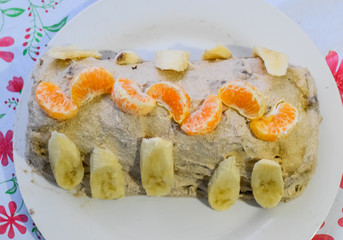 Cake with banana and tangerines, sprinkled with chocolate.
